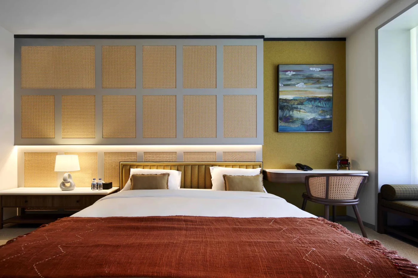 Modern open-plan room with blue mosaic tiled kitchen island, bar stools, blue sofa, bed, and large windows overlooking tropical garden. - Bali Villas