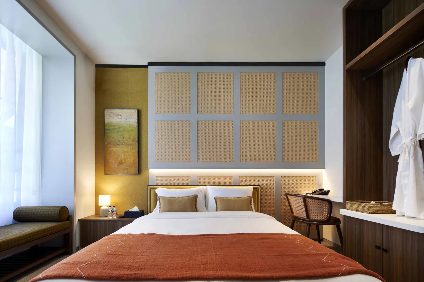 Modern open-plan room with blue mosaic tiled kitchen island, bar stools, blue sofa, bed, and large windows overlooking tropical garden. - Bali Villas