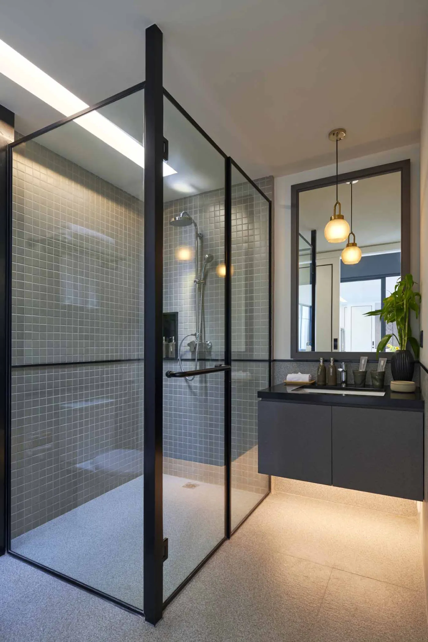 Modern open-plan room with blue mosaic tiled kitchen island, bar stools, blue sofa, bed, and large windows overlooking tropical garden. - Bali Villas