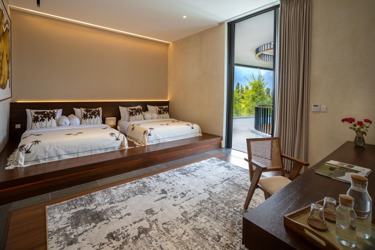 Modern luxury bathroom with freestanding white bathtub, gray stone walls, glass shower, and minimalist vanity. - Bali Villas
