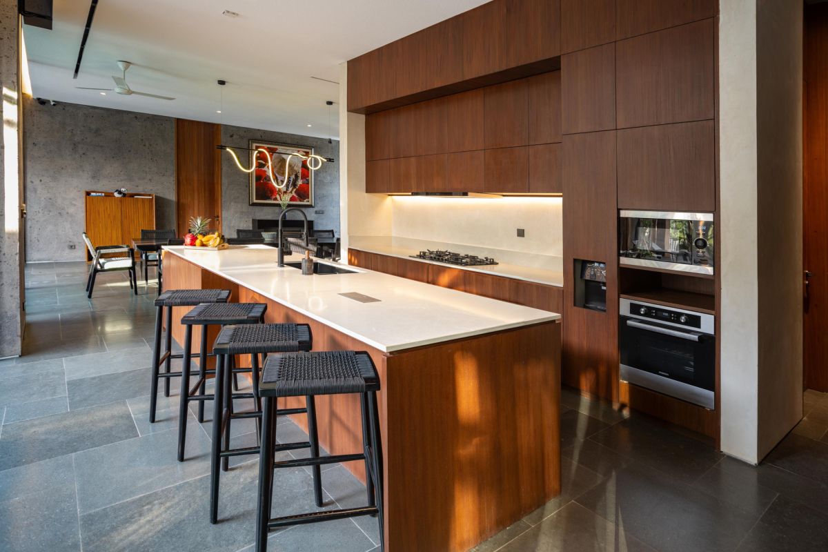 Modern luxury bathroom with freestanding white bathtub, gray stone walls, glass shower, and minimalist vanity. - Bali Villas