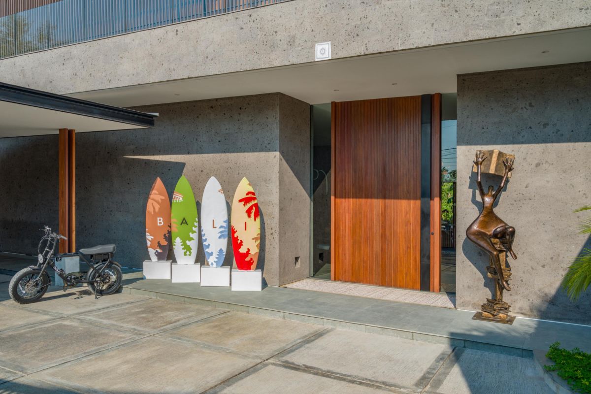 Modern luxury bathroom with freestanding white bathtub, gray stone walls, glass shower, and minimalist vanity. - Bali Villas
