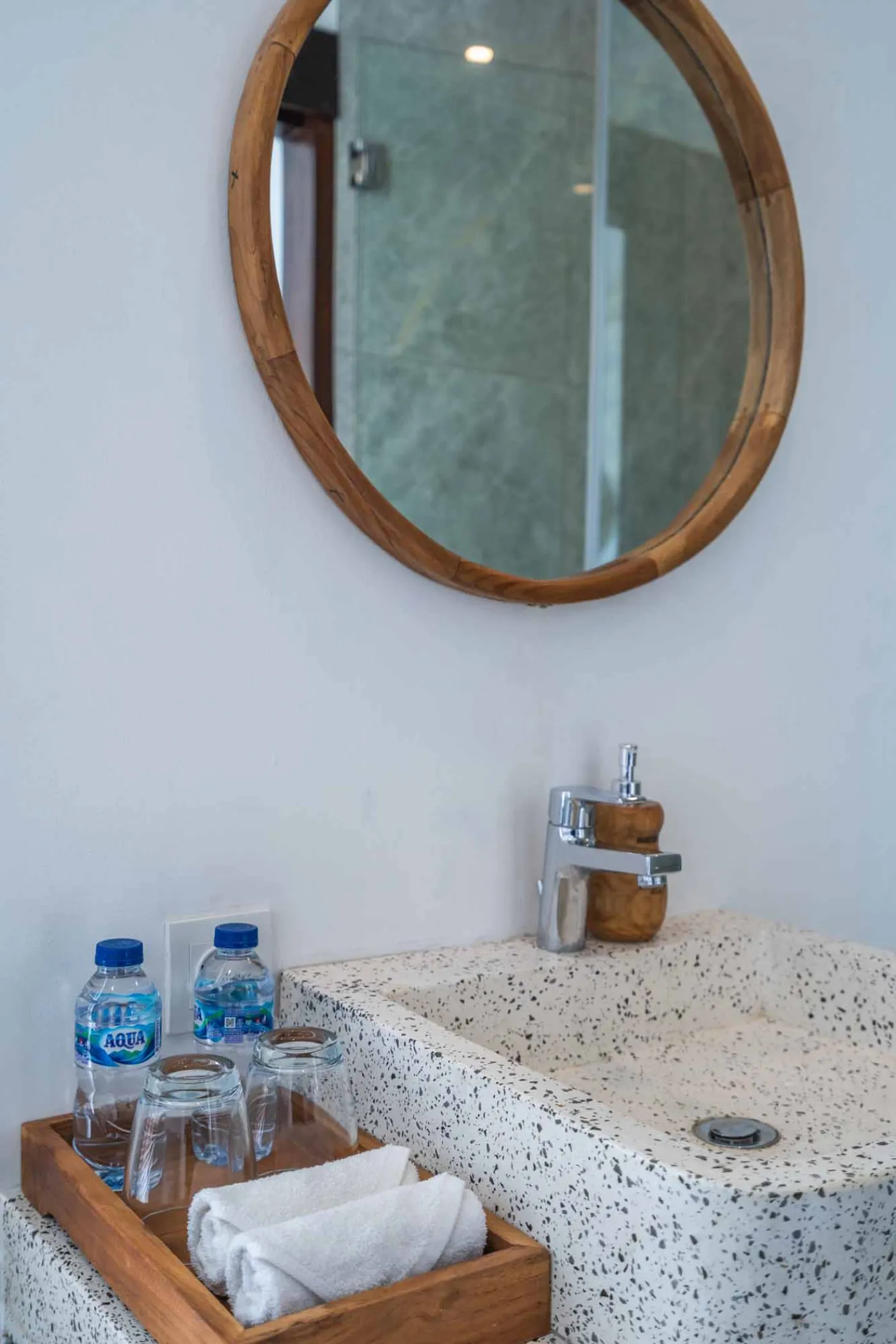 Blue and white striped towels rolled on a teal poolside lounger at a tropical resort villa. - Bali Villas