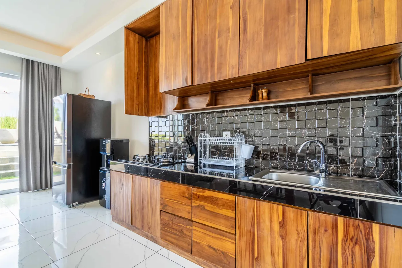 Modern tropical bathroom featuring brick-tiled shower, wooden vanity sink, toilet, and woven accents. - Bali Villas