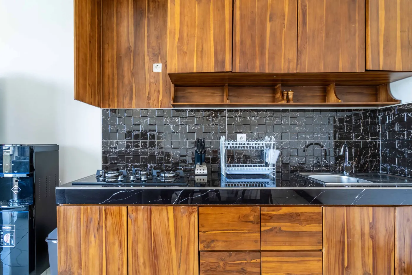 Modern tropical bathroom featuring brick-tiled shower, wooden vanity sink, toilet, and woven accents. - Bali Villas