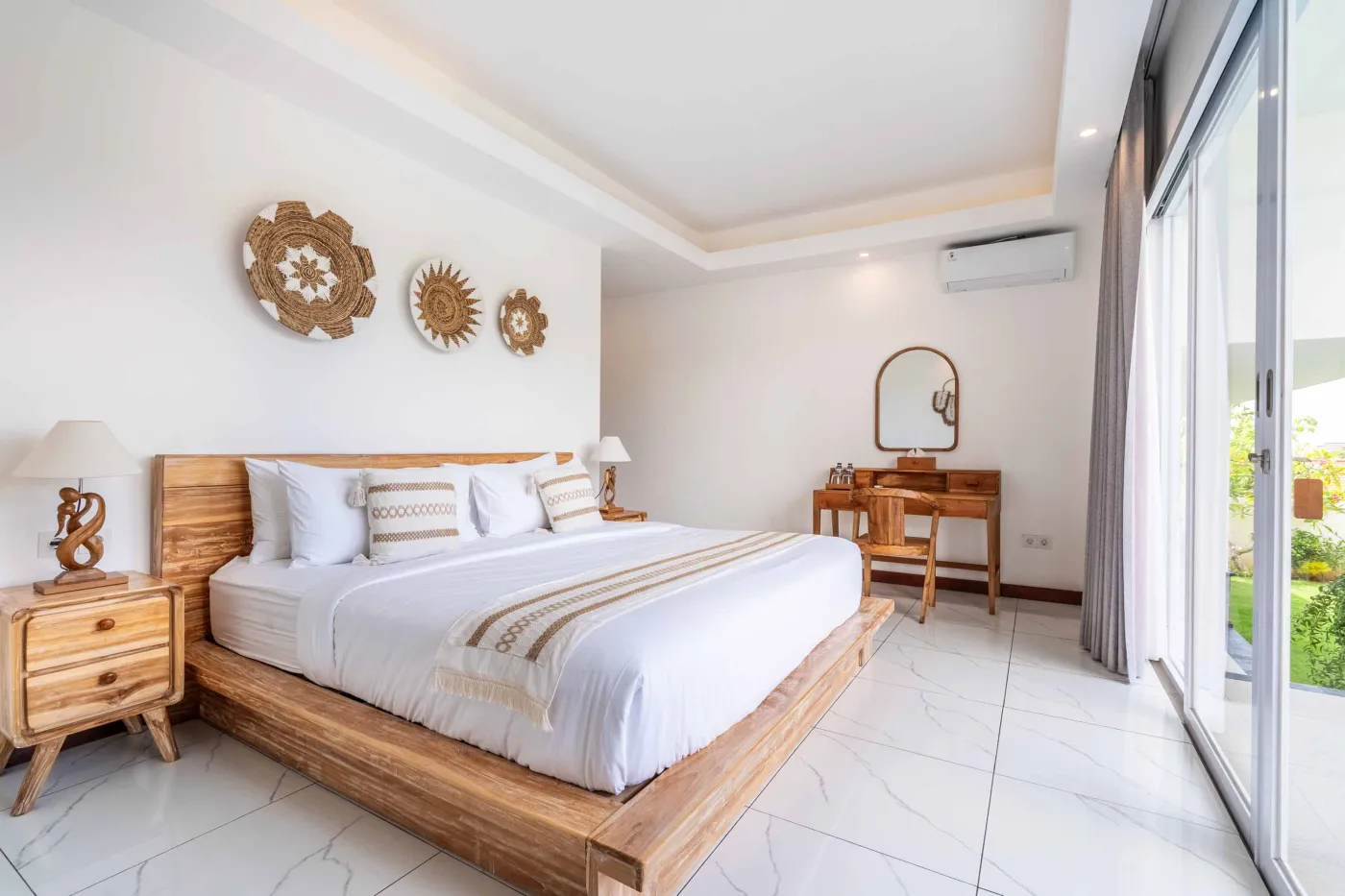 Modern tropical bathroom featuring brick-tiled shower, wooden vanity sink, toilet, and woven accents. - Bali Villas