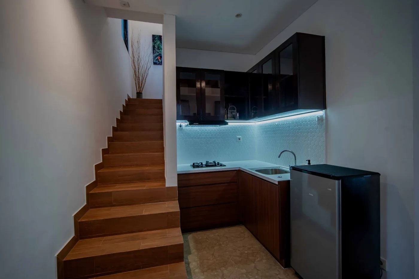 Modern hotel bathroom with double vanity sinks, large framed mirror, and frosted glass shower enclosure. - Bali Villas