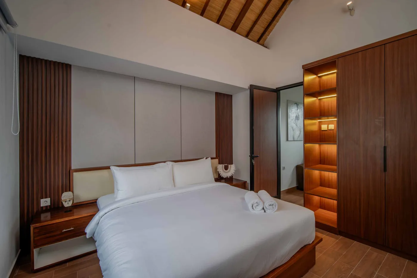 Modern hotel bathroom with double vanity sinks, large framed mirror, and frosted glass shower enclosure. - Bali Villas