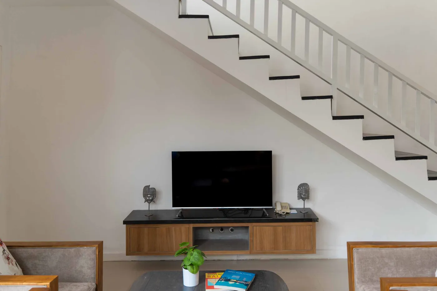 Modern tropical villa dining area with wooden table, orchids, and sliding doors to infinity pool. - Bali Villas