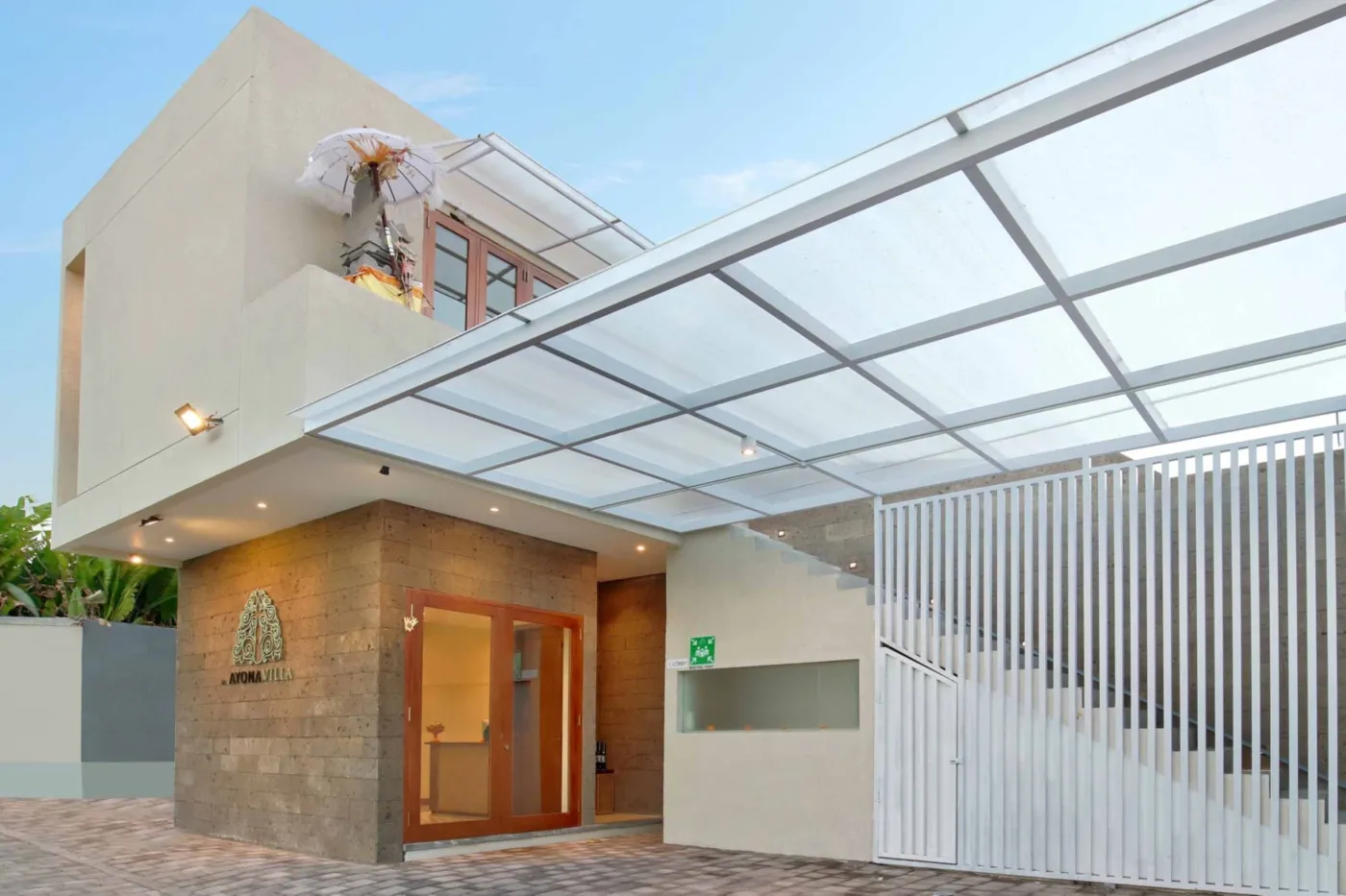 Romantic couple embracing on a modern balcony at sunset, surrounded by tropical plants. - Bali Villas