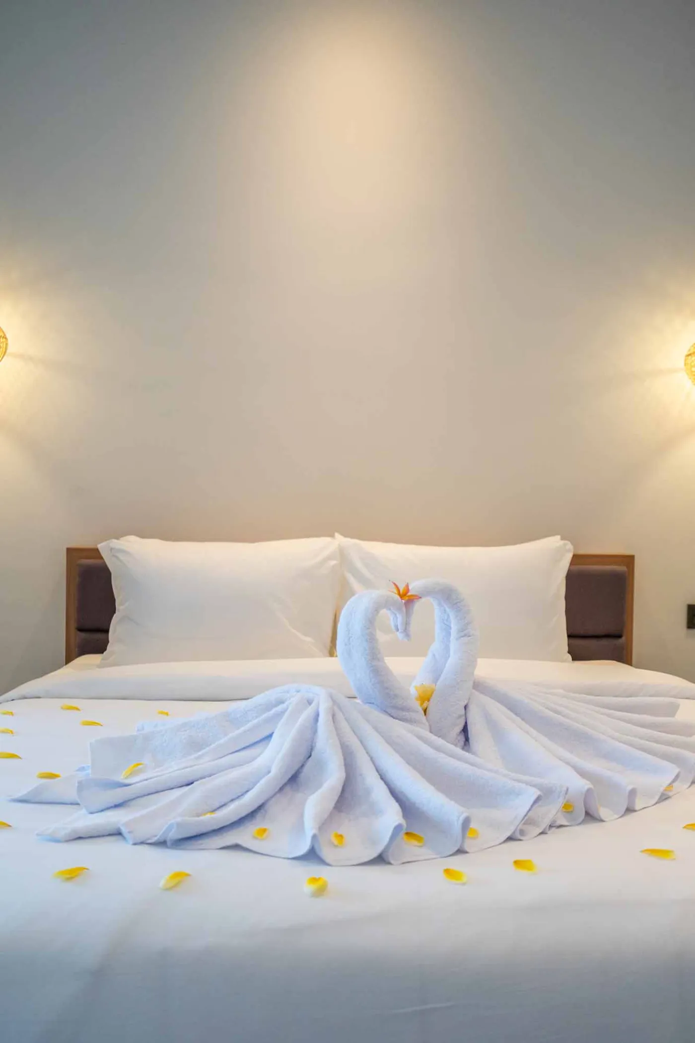 Modern Balinese-style bathroom with glass shower enclosure, round wooden mirror, stone vanity, and stacked towels. - Bali Villas