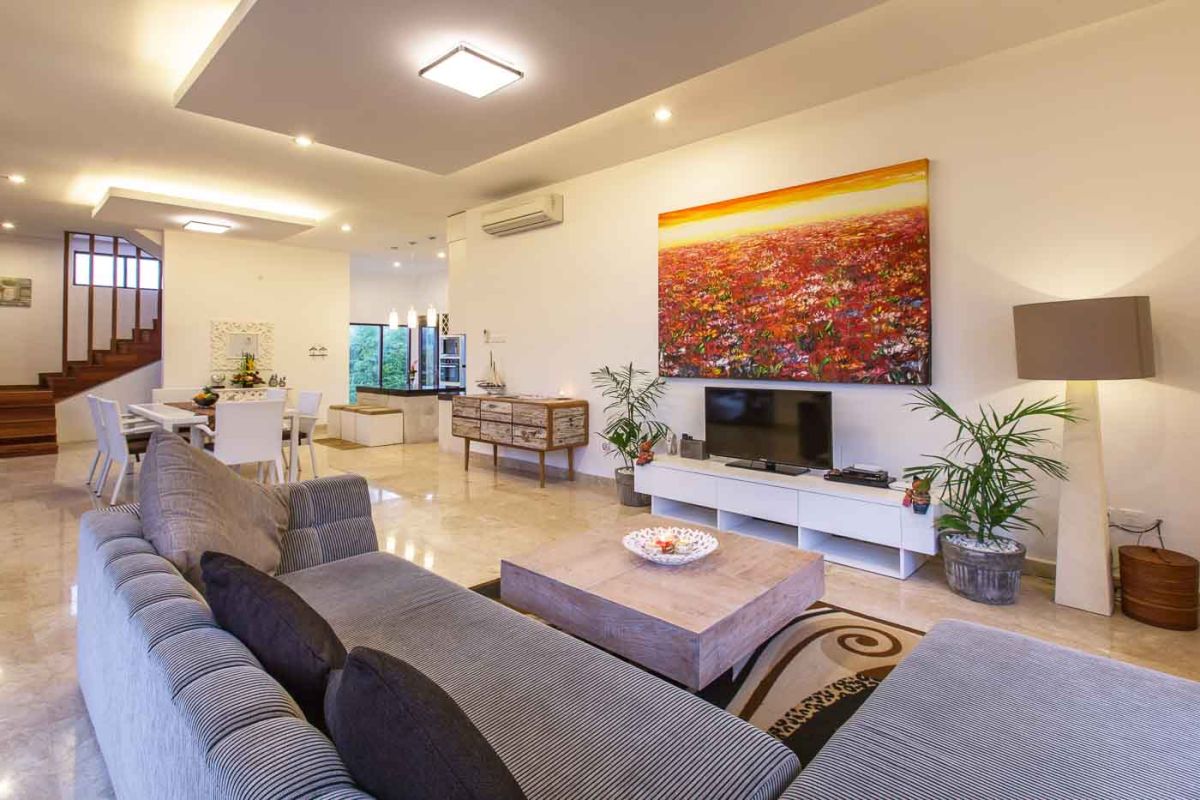 Luxurious Balinese bathroom with freestanding stone bathtub, tropical garden view, and floating frangipani petals. - Bali Villas