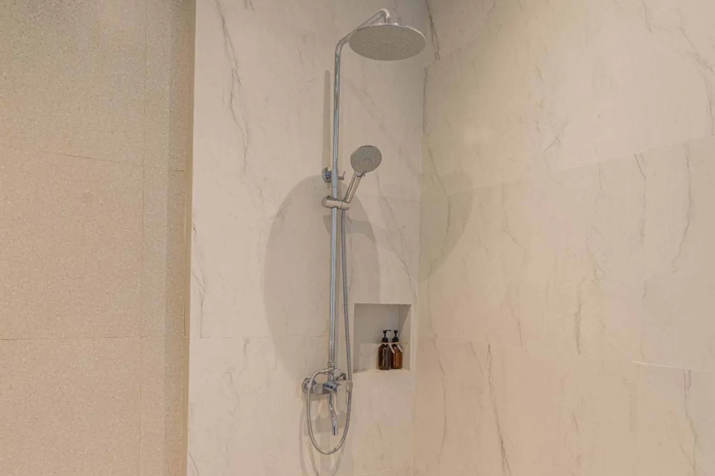 Woven bamboo pendant lights hanging in a modern tropical room with gray curtains, wooden shelves, and infinity pool view. - Bali Villas