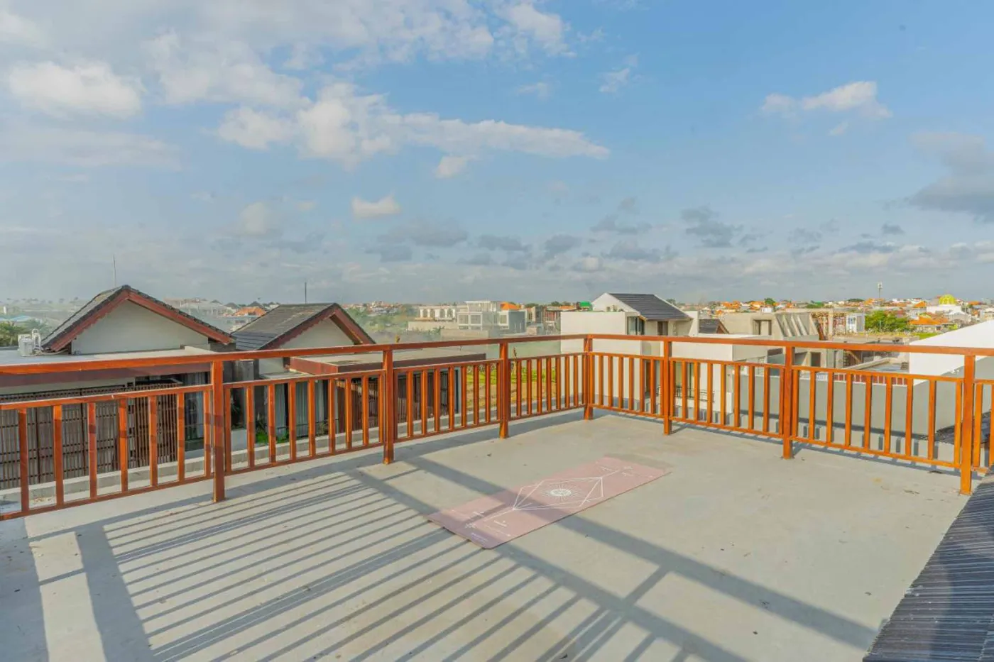 Woven bamboo pendant lights hanging in a modern tropical room with gray curtains, wooden shelves, and infinity pool view. - Bali Villas