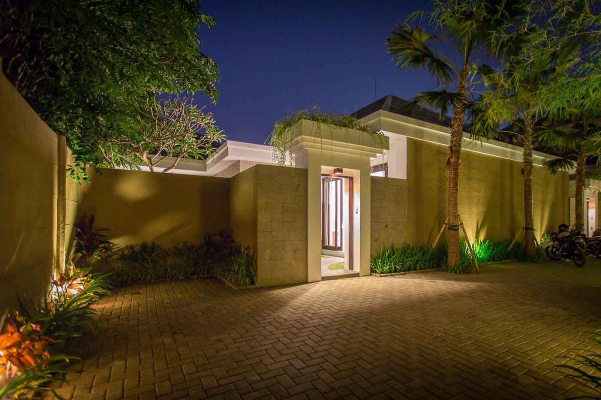 Modern luxury bathroom with wooden double vanity, white marble countertop, orchids, and folded towels. - Bali Villas