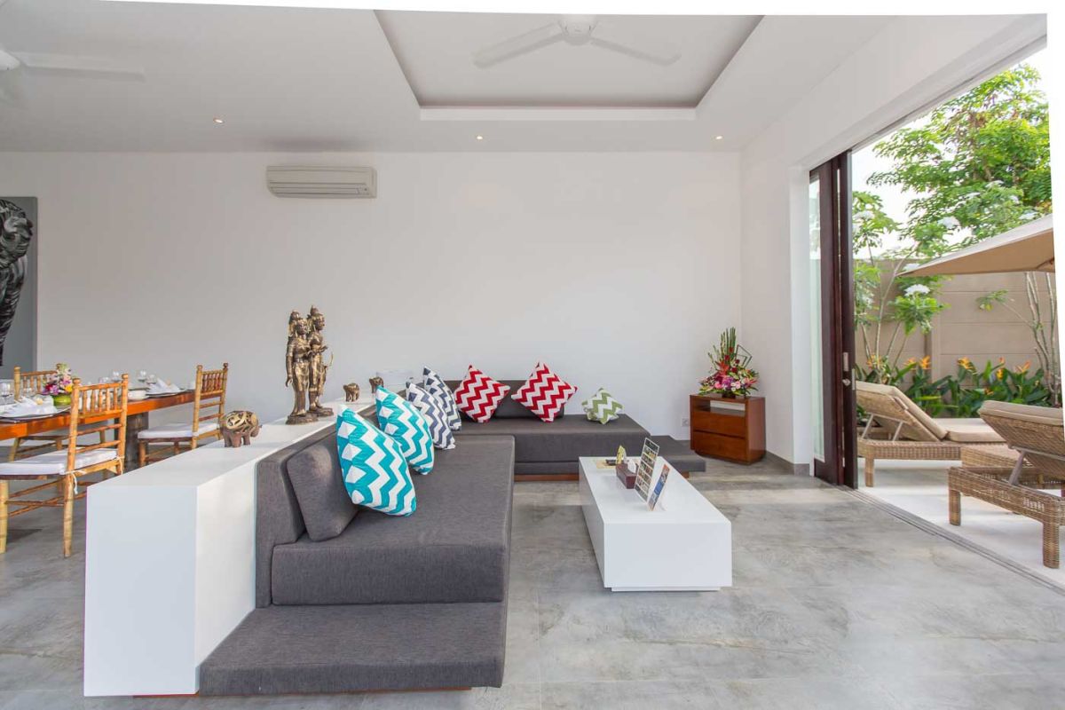 Modern luxury bathroom with wooden double vanity, white marble countertop, orchids, and folded towels. - Bali Villas
