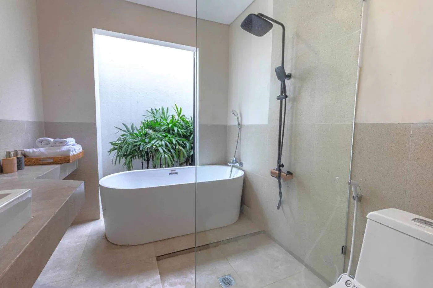 Modern minimalist kitchen with wooden cabinets, white orchids on a central table, fridge, and sink. - Bali Villas