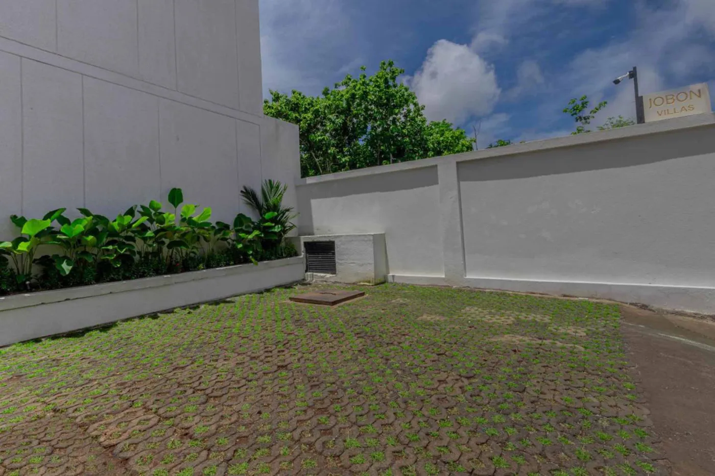 Modern minimalist kitchen with wooden cabinets, white orchids on a central table, fridge, and sink. - Bali Villas