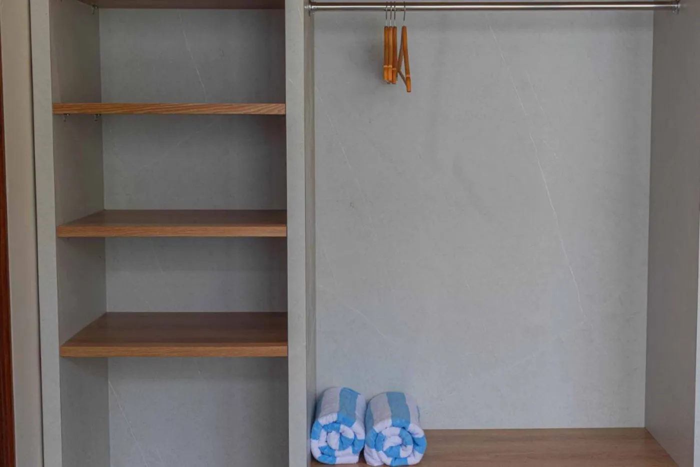 Modern minimalist kitchen with wooden cabinets, white orchids on a central table, fridge, and sink. - Bali Villas