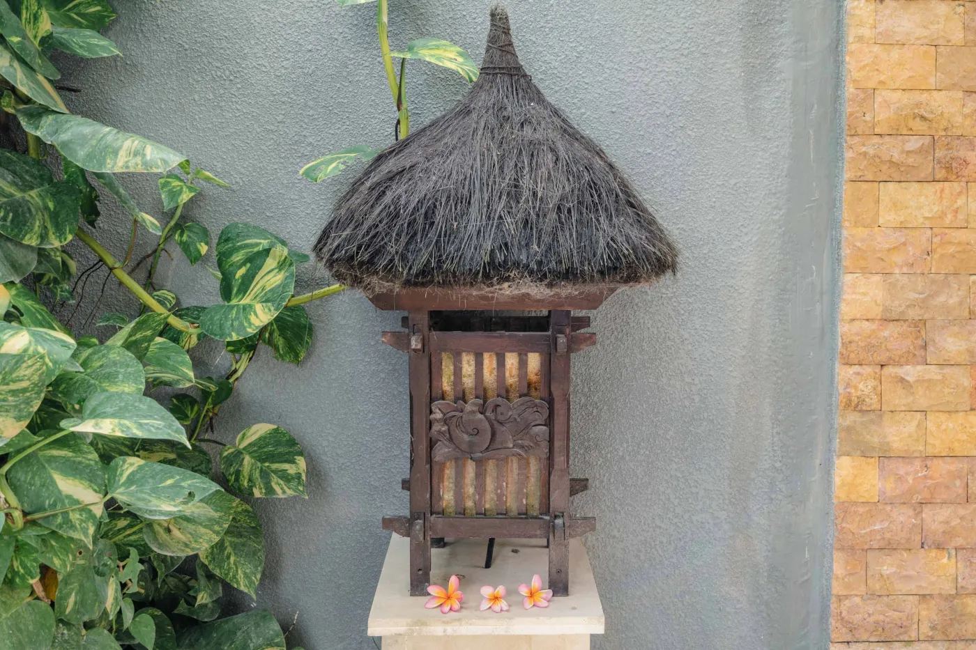 Balinese kitchen with wooden cabinets, checkered tiled backsplash, and dining table overlooking a private pool. - Bali Villas