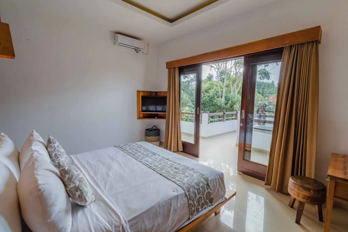 Balinese kitchen with wooden cabinets, checkered tiled backsplash, and dining table overlooking a private pool. - Bali Villas