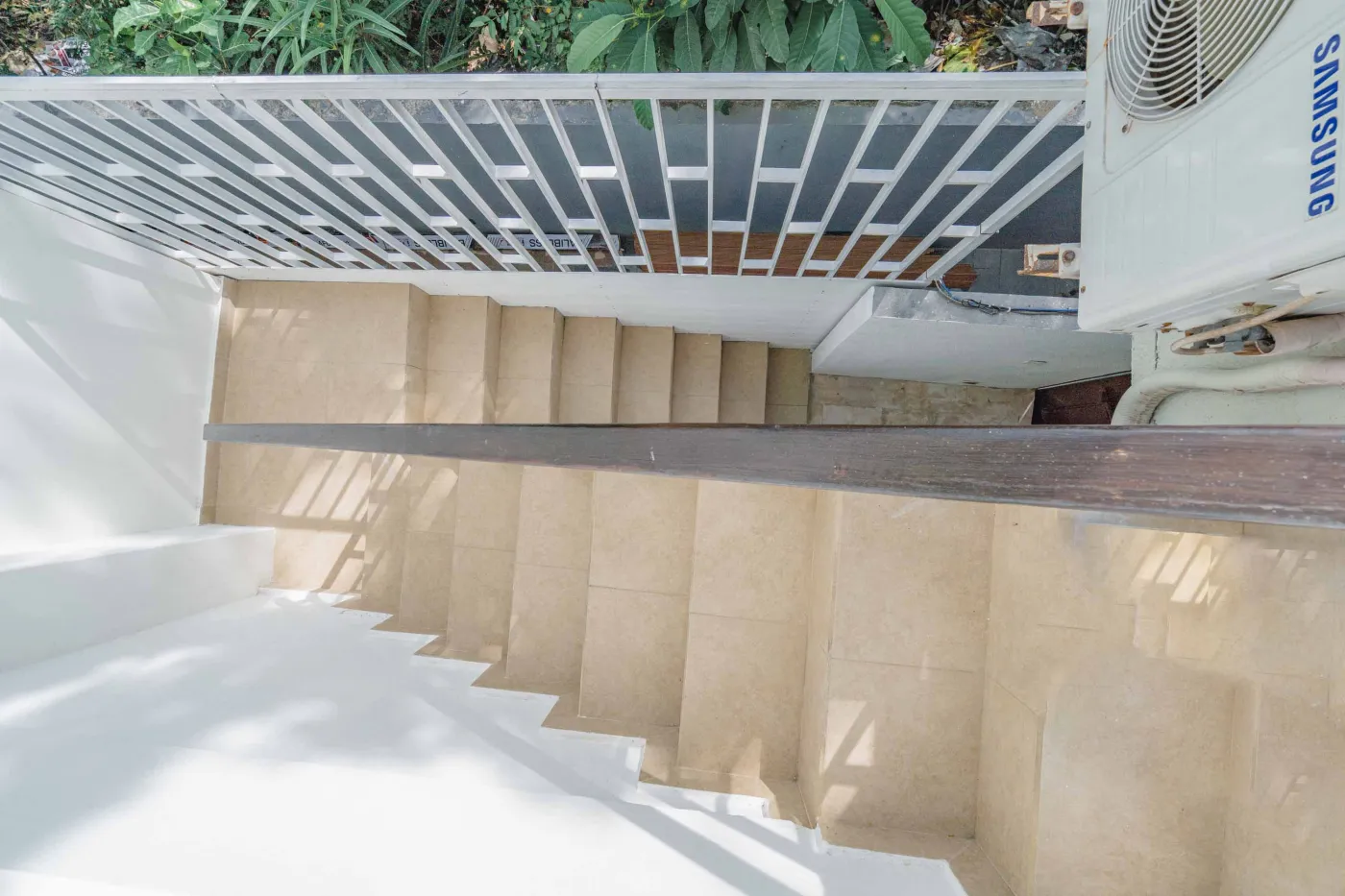 Balinese kitchen with wooden cabinets, checkered tiled backsplash, and dining table overlooking a private pool. - Bali Villas