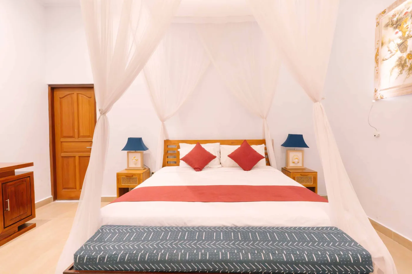 Spacious modern bathroom with white vanity, ornate mirror, toilet, and tropical garden view through frosted glass door. - Bali Villas