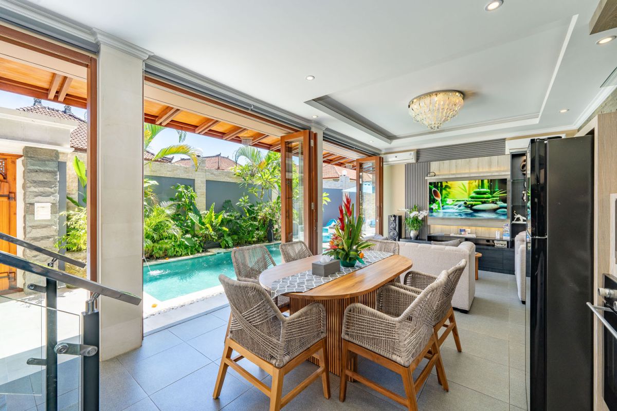 Spacious Balinese terrace pavilion with white rattan sofa, blue cushions, coffee table, and ocean horizon view. - Bali Villas