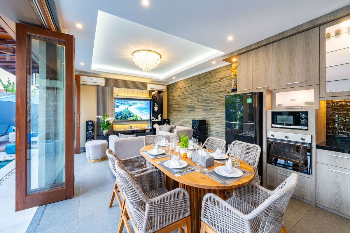 Spacious Balinese terrace pavilion with white rattan sofa, blue cushions, coffee table, and ocean horizon view. - Bali Villas