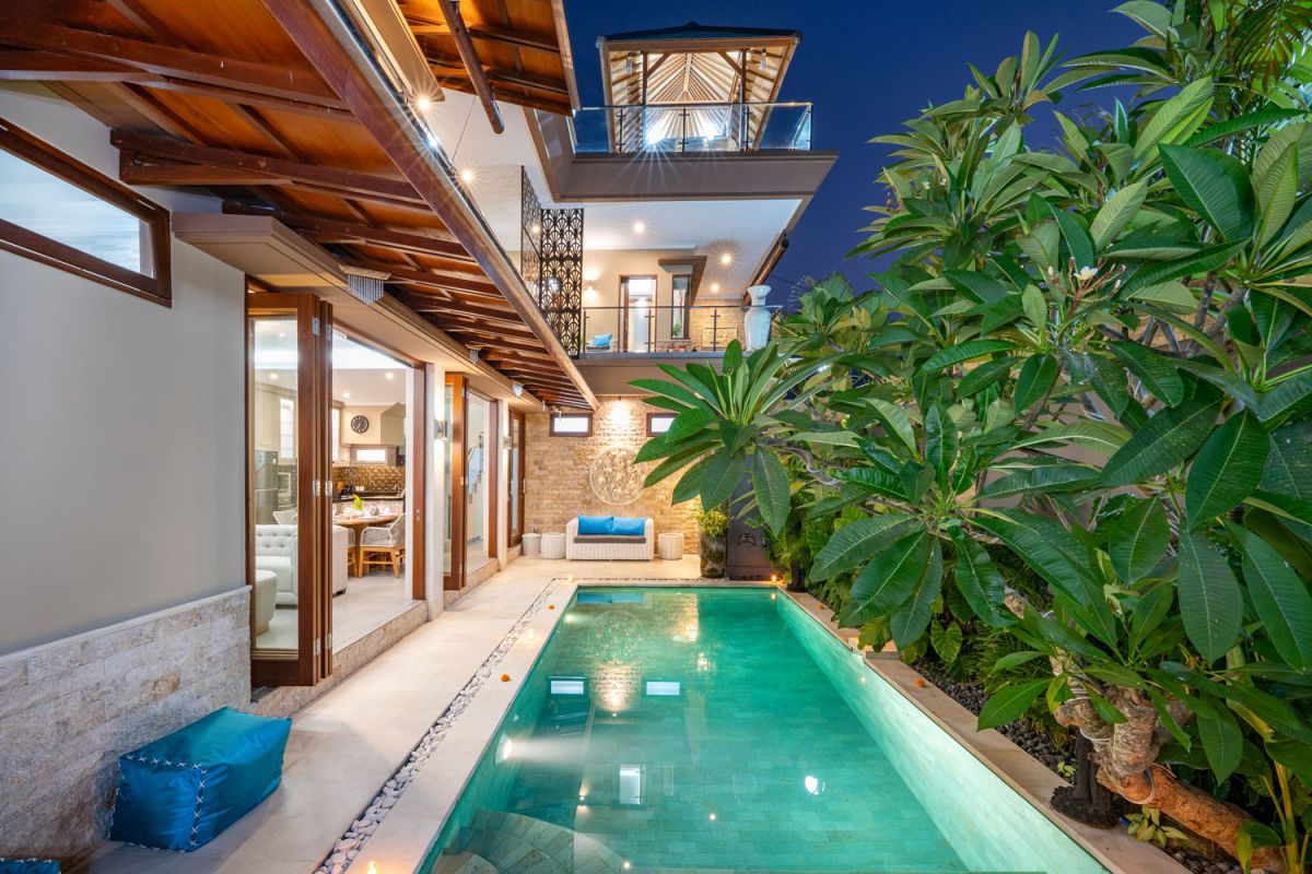 Spacious Balinese terrace pavilion with white rattan sofa, blue cushions, coffee table, and ocean horizon view. - Bali Villas
