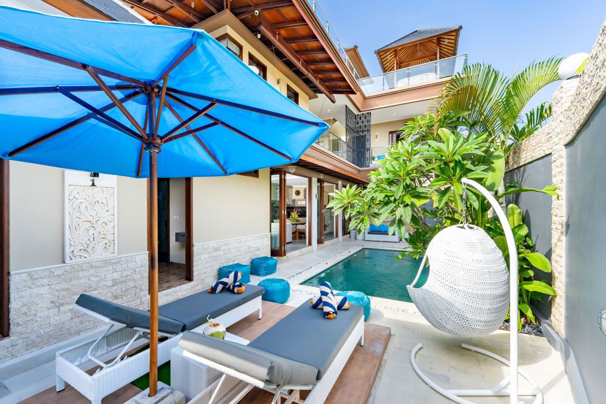 Spacious Balinese terrace pavilion with white rattan sofa, blue cushions, coffee table, and ocean horizon view. - Bali Villas