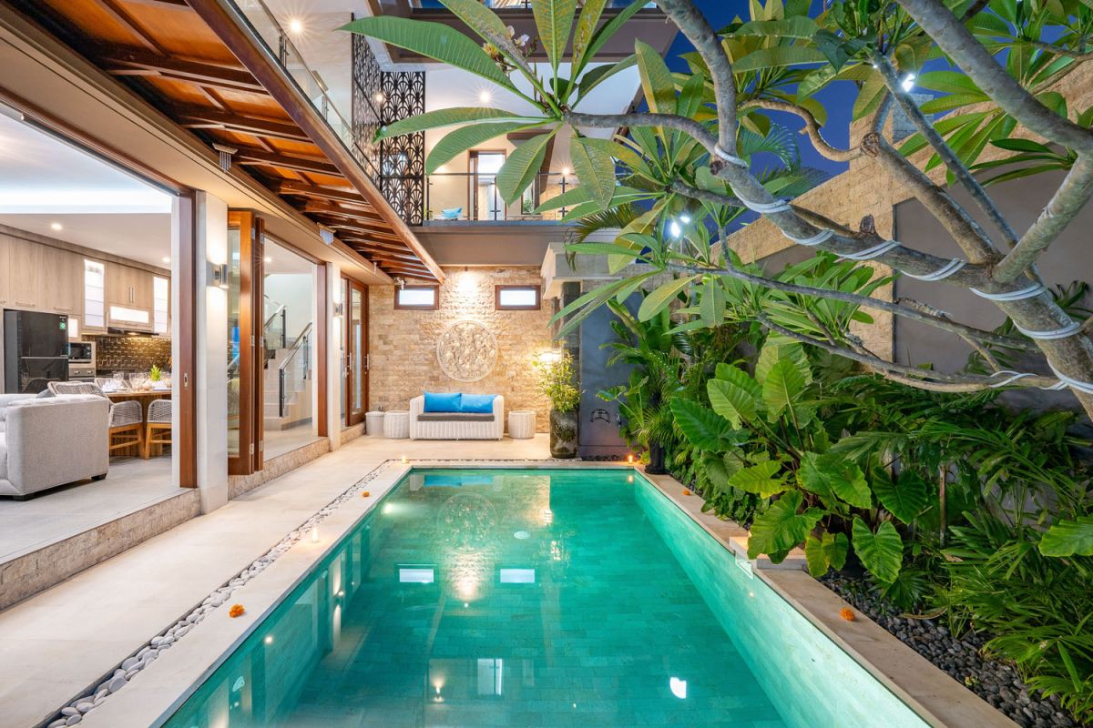 Spacious Balinese terrace pavilion with white rattan sofa, blue cushions, coffee table, and ocean horizon view. - Bali Villas