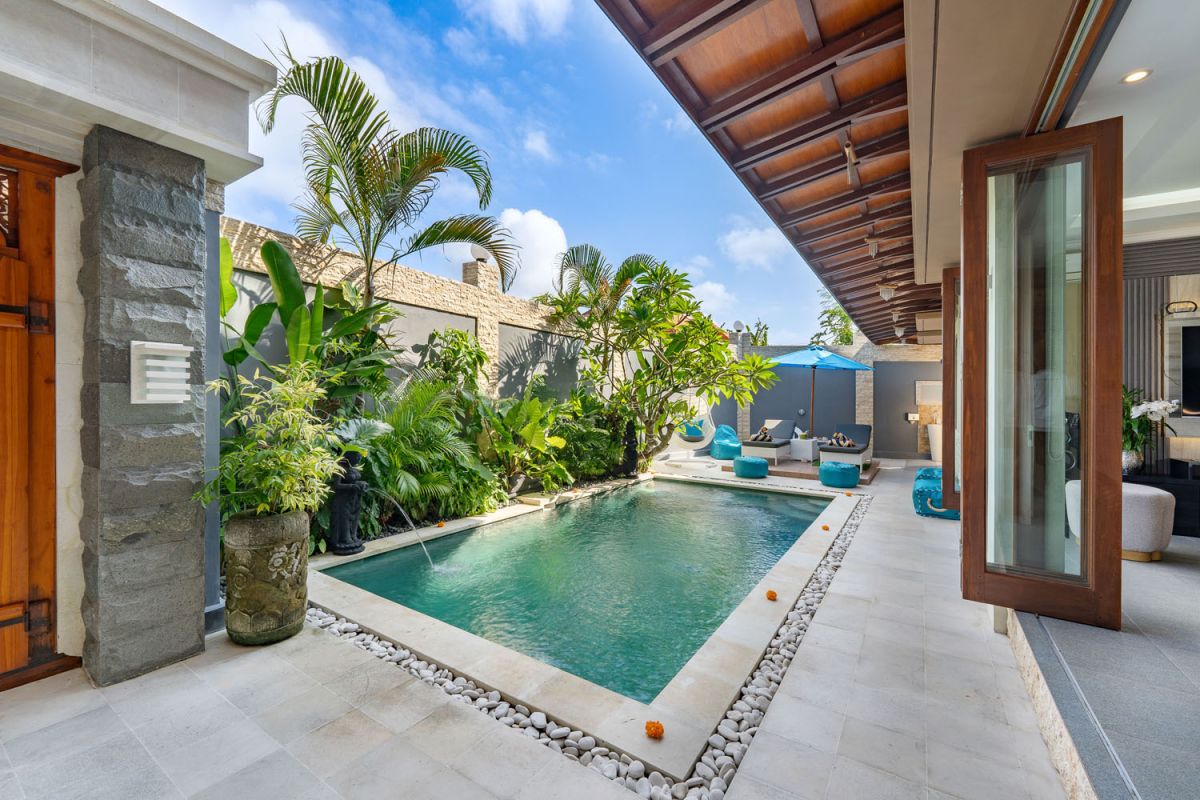 Spacious Balinese terrace pavilion with white rattan sofa, blue cushions, coffee table, and ocean horizon view. - Bali Villas