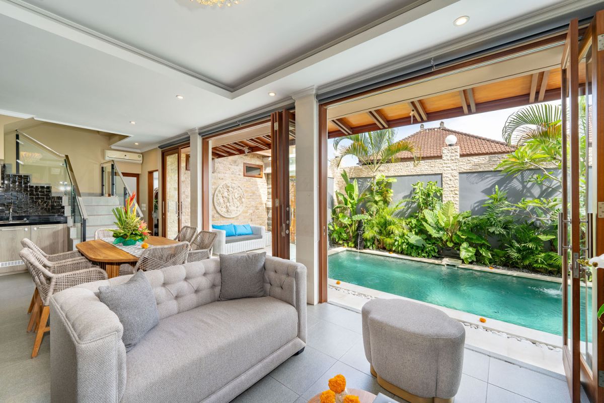 Spacious Balinese terrace pavilion with white rattan sofa, blue cushions, coffee table, and ocean horizon view. - Bali Villas