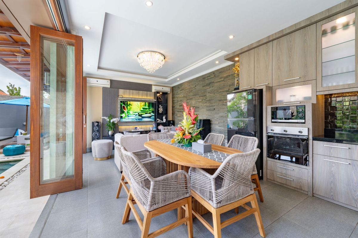 Spacious Balinese terrace pavilion with white rattan sofa, blue cushions, coffee table, and ocean horizon view. - Bali Villas
