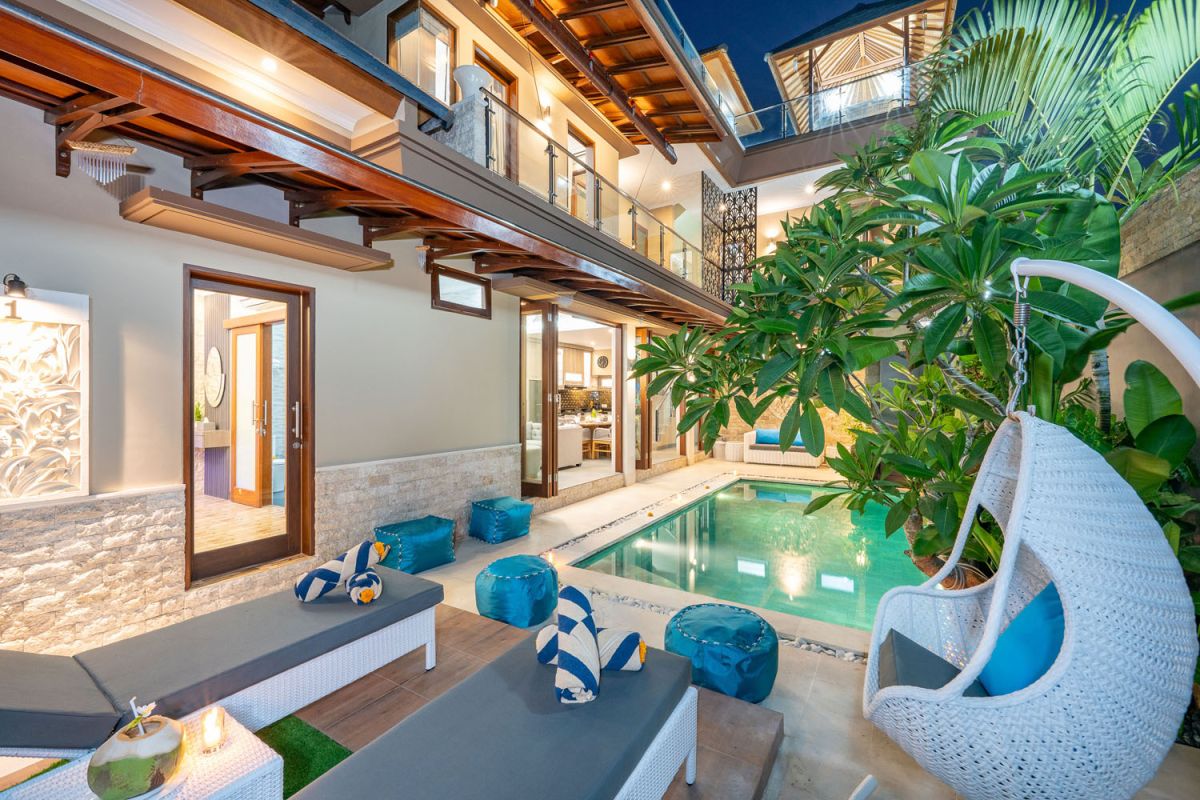 Spacious Balinese terrace pavilion with white rattan sofa, blue cushions, coffee table, and ocean horizon view. - Bali Villas