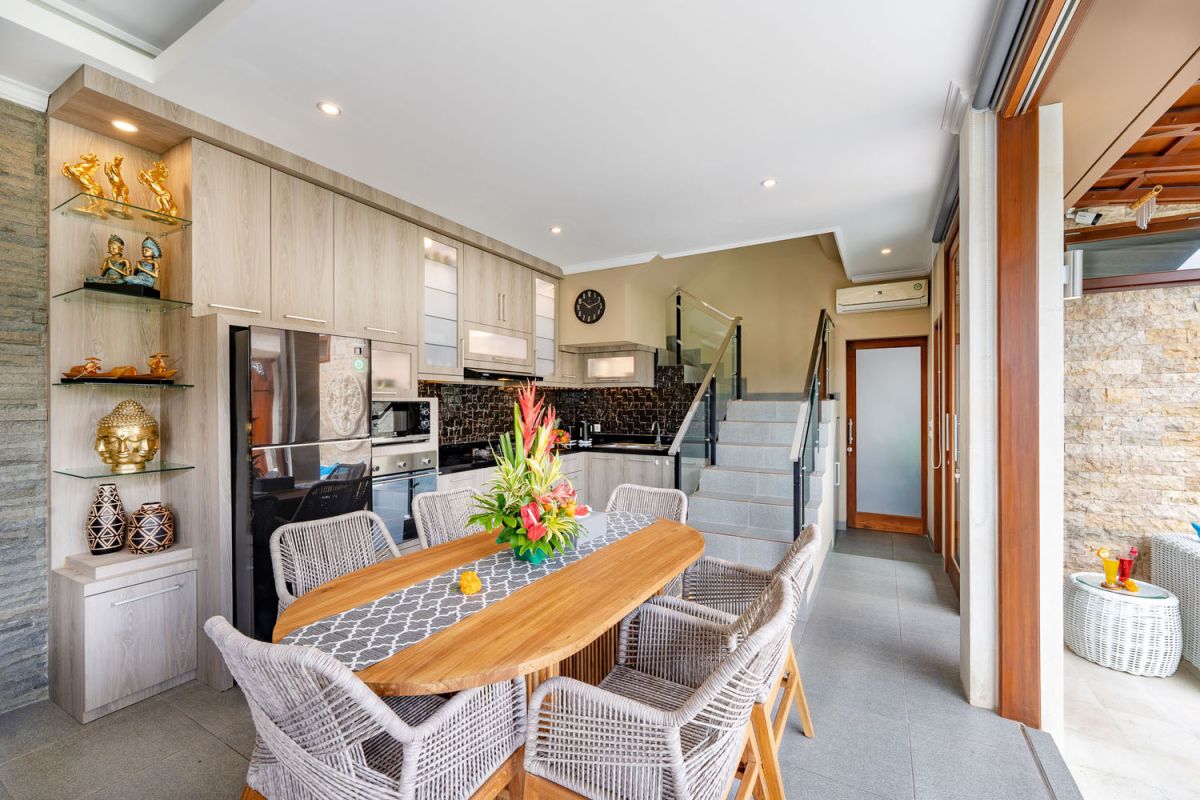 Spacious Balinese terrace pavilion with white rattan sofa, blue cushions, coffee table, and ocean horizon view. - Bali Villas