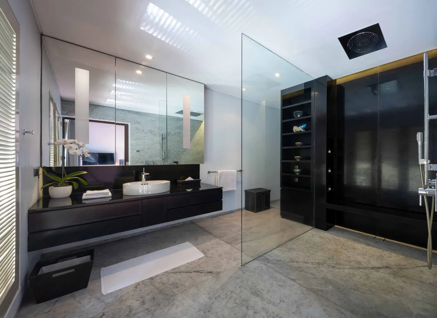 Curved stone terrace with white cushioned lounge overlooking Bali beach, ocean, and tropical gardens. - Bali Villas