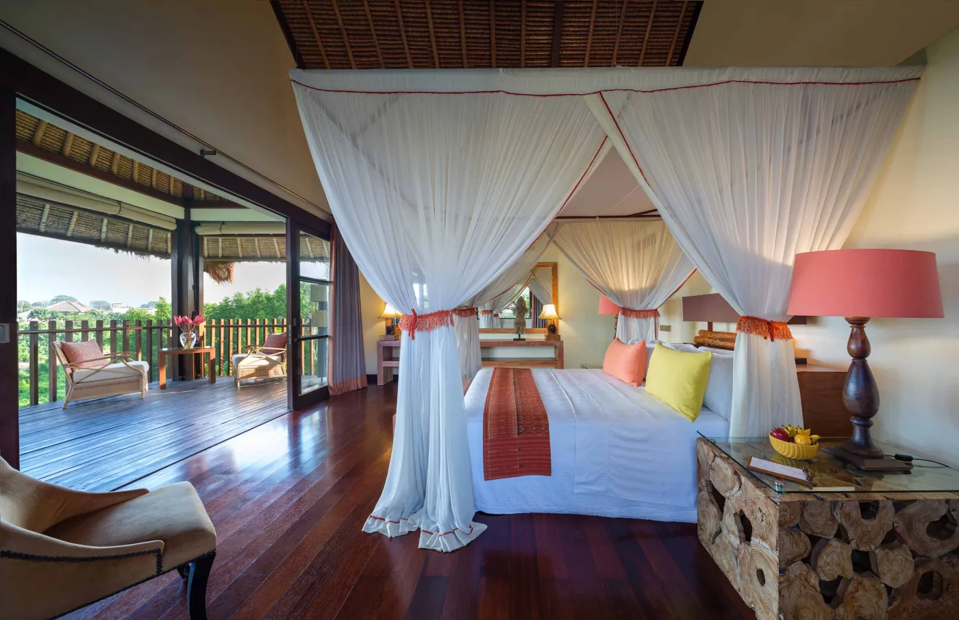 Curved stone terrace with white cushioned lounge overlooking Bali beach, ocean, and tropical gardens. - Bali Villas