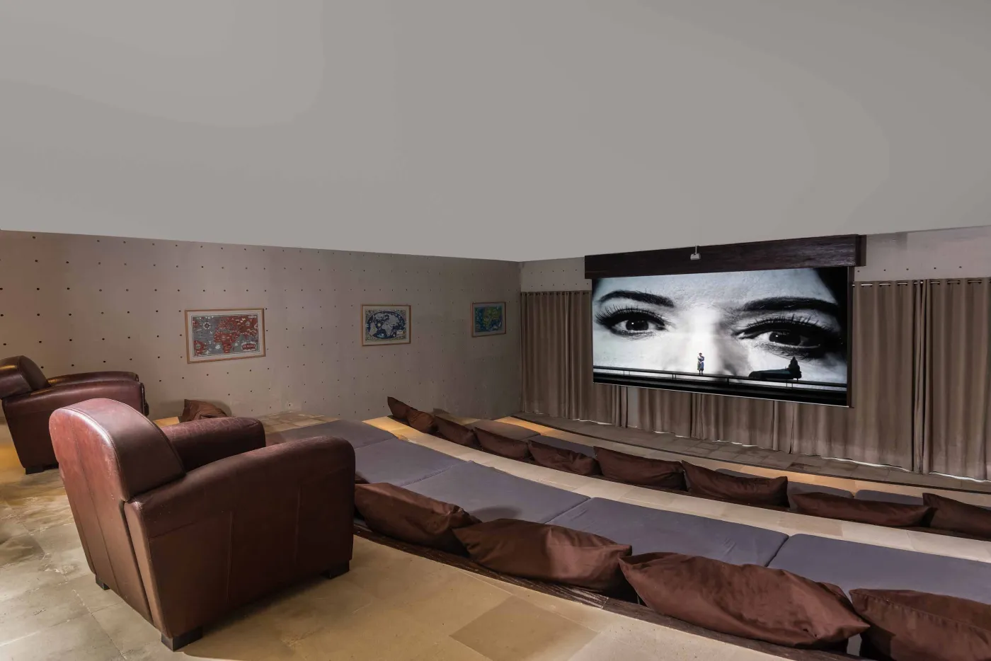 Spacious Balinese pavilion interior with thatched roof, white modular sofas, woven accents, and lush garden view through open wooden frames. - Bali Villas