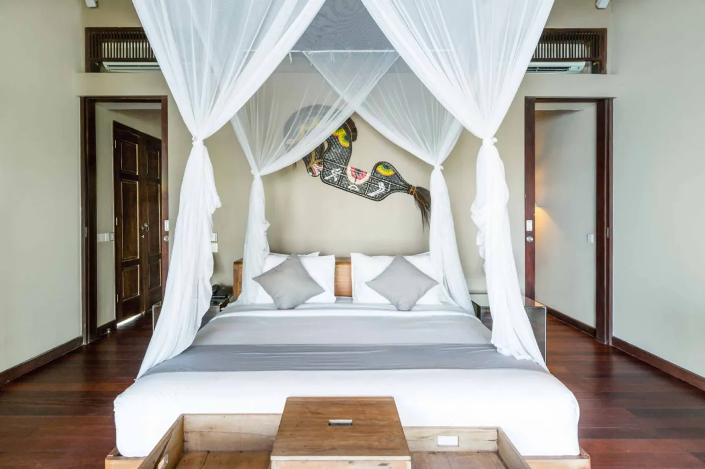 Luxury infinity pool at Bali beach resort, with loungers, umbrellas, tropical trees, and ocean view. - Bali Villas