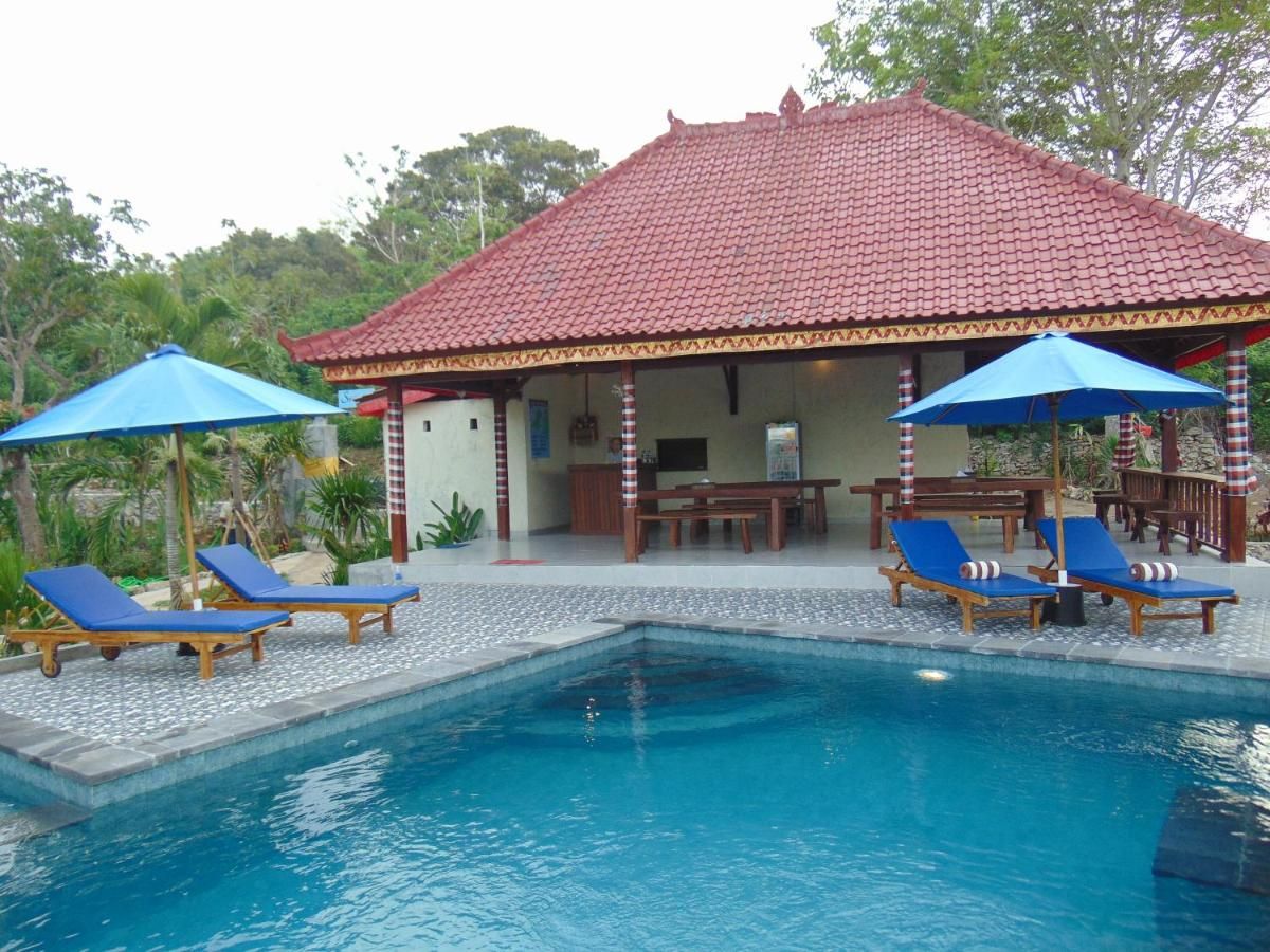 Rustic tropical bathroom with wooden walls, pebble tile floor, woven sink basin, and open shower. - Bali Villas