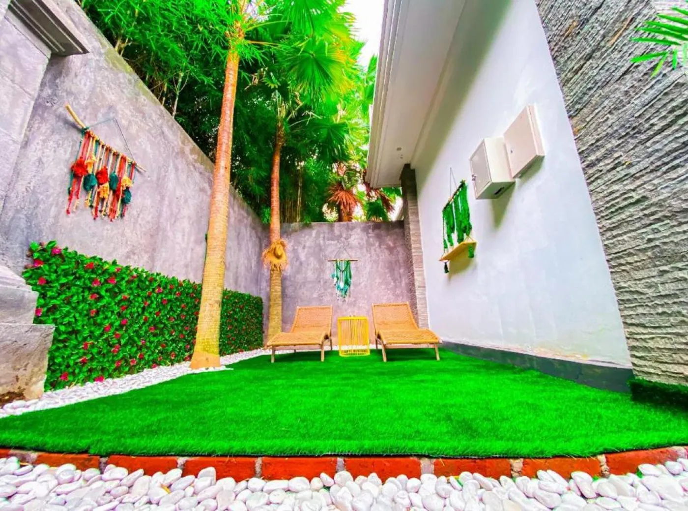 Cozy Balinese villa dining area with wooden table and chairs, kitchenette, framed Hindu deity artwork, and modern LED lighting. - Bali Villas