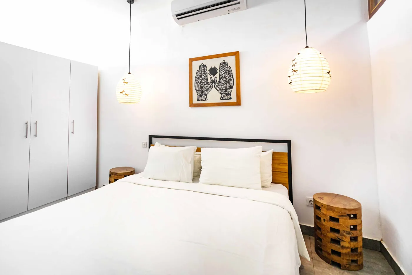 Cozy modern living room with green velvet sofa, wooden coffee table, potted plant, and adjacent white kitchen. - Bali Villas