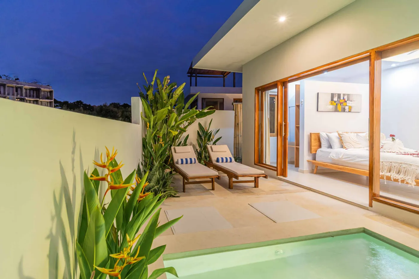 Modern minimalist interior with wooden desk, potted cactus in round window, rattan lamp, and tiled flooring. - Bali Villas