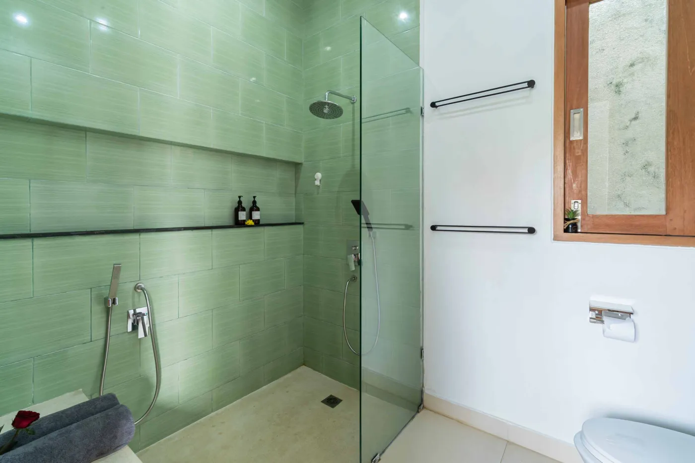 Modern minimalist interior with wooden desk, potted cactus in round window, rattan lamp, and tiled flooring. - Bali Villas