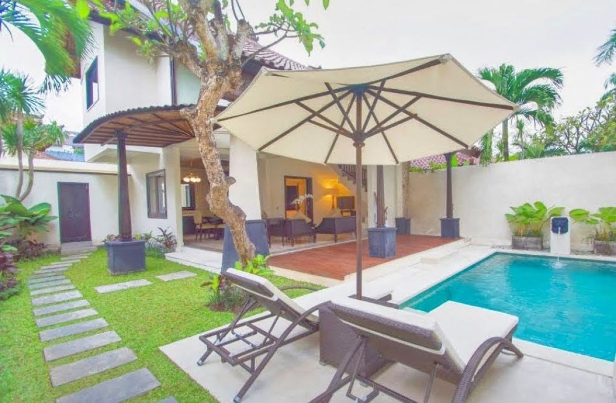 Luxurious Balinese villa bedroom with king bed, red accents, and sliding doors to private infinity pool. - Bali Villas