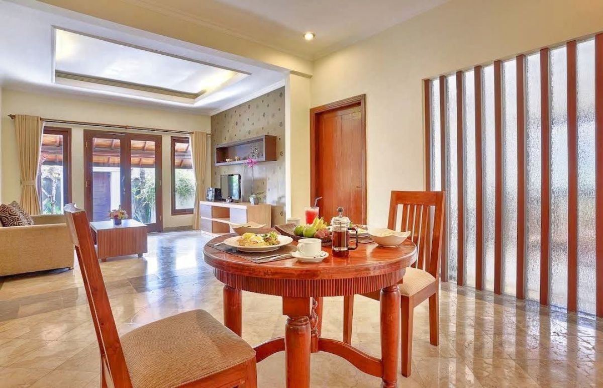 Luxurious Balinese villa bedroom with king bed, red accents, and sliding doors to private infinity pool. - Bali Villas