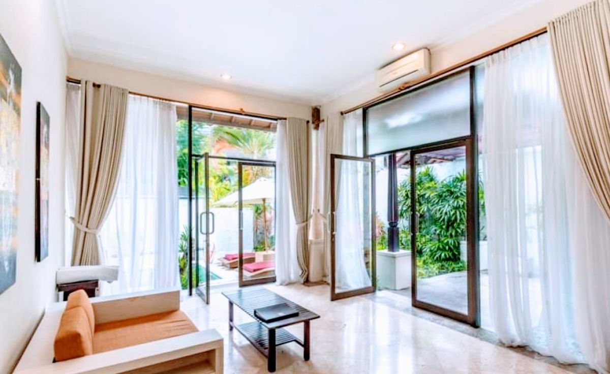 Luxurious Balinese villa bedroom with king bed, red accents, and sliding doors to private infinity pool. - Bali Villas