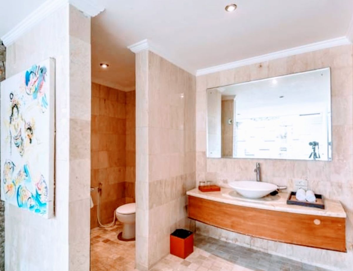 Luxurious Balinese villa bedroom with king bed, red accents, and sliding doors to private infinity pool. - Bali Villas